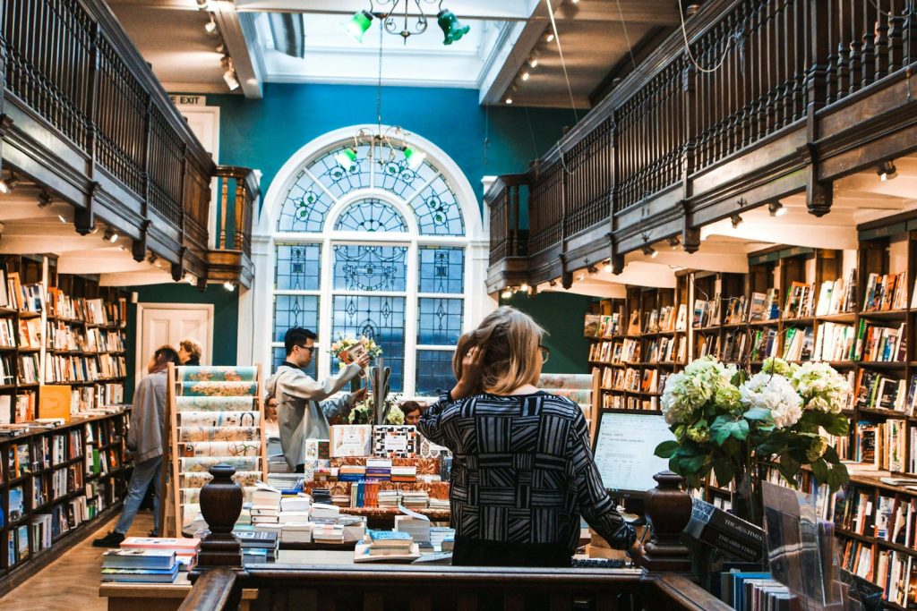 Readers browsing the shelves of a traditional bookshop with wooden galleries