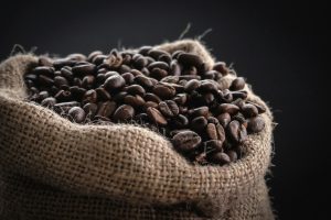 Roasted coffee beans spilling from a hessian sack