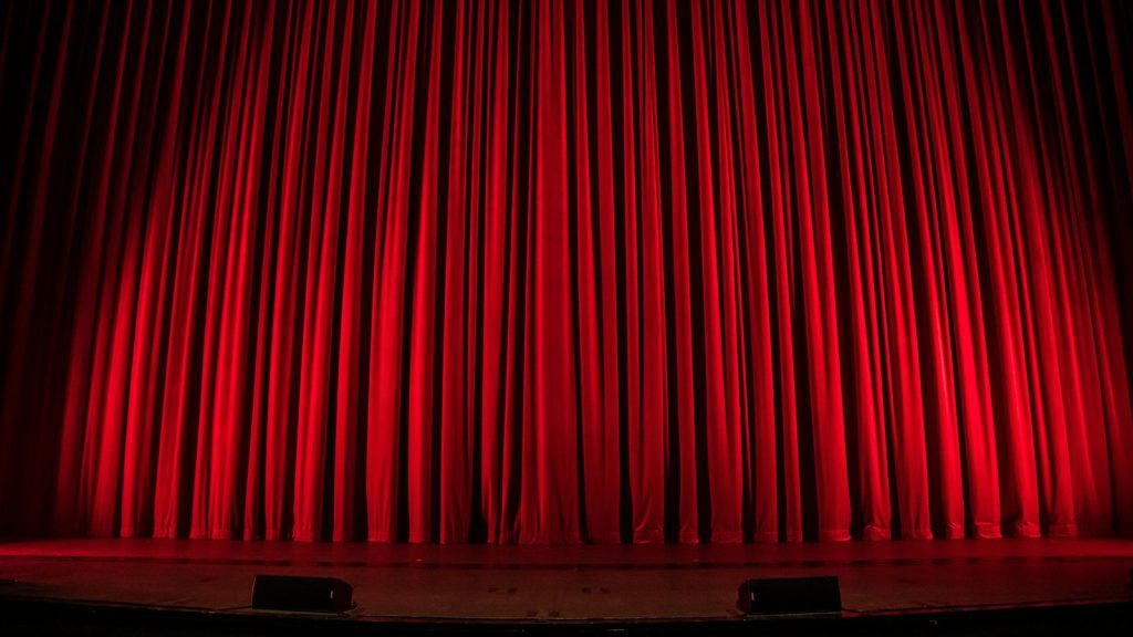 Red velvet stage curtain under warm light