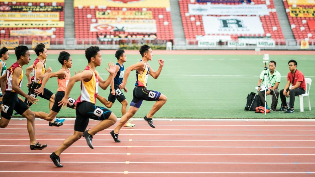 Group of runners racing on a red athletics track