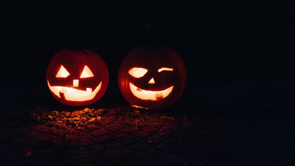 Two glowing jack-o'-lanterns at night