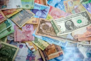 Banknotes from many countries spread across a table
