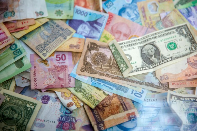 Banknotes from many countries spread across a table