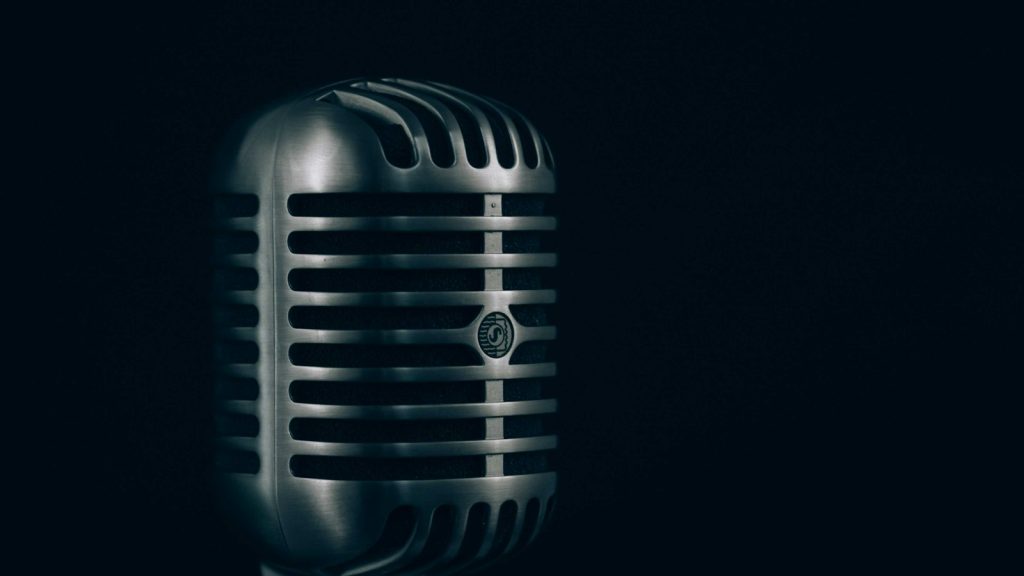 Vintage condenser microphone on a dark stage