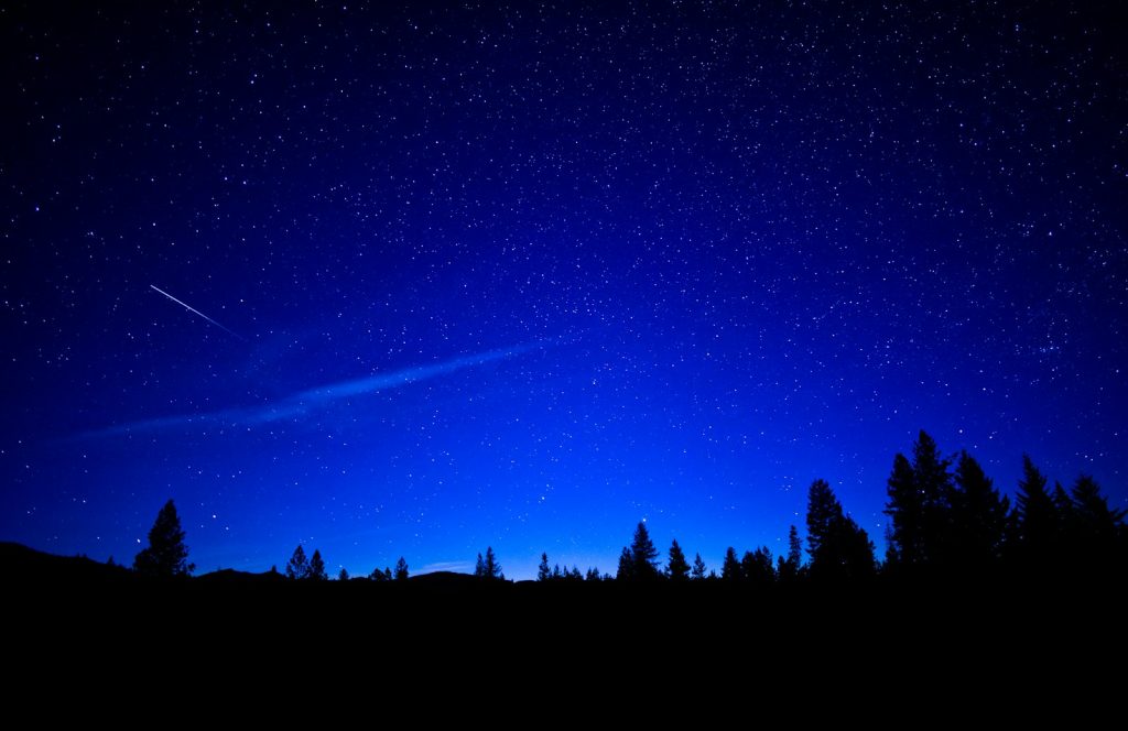 Shooting star streaking across a starry night sky