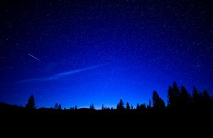 Shooting star streaking across a starry night sky