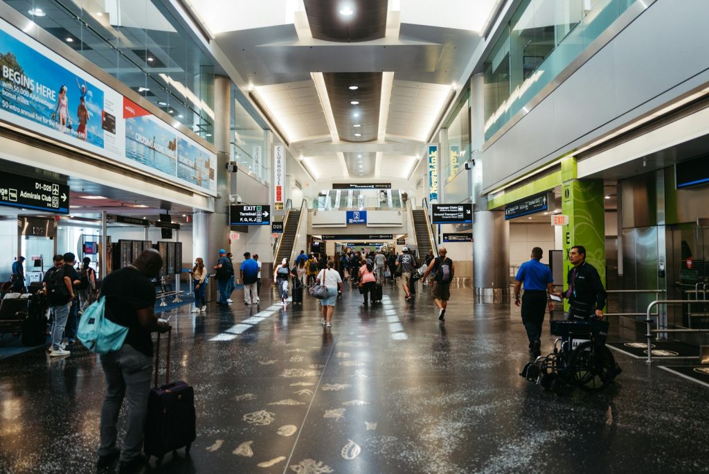 Travellers walking through a busy airport terminal